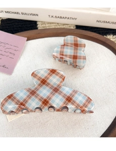 Détail de pinces à cheveux à carreaux bleus et marrons en tailles large et petite