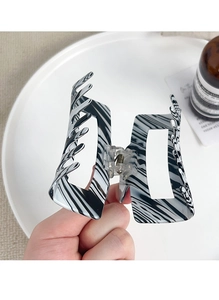 Detailed macro of black and white marble pattern large hair claw clip with metal spring