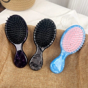 Three-piece set of marble pattern acetate hair brushes in a rustic woven basket