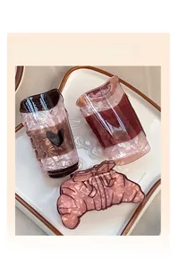 Lot de trois pinces à cheveux en acétate, formes croissant et tasse, texture marbrée