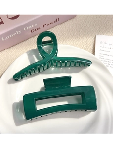 Detail of vintage dark green resin hair claws in a rectangular and spiral cross design