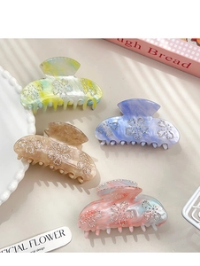 Macro detail of French style acetate hair claws with sparkling rhinestone flower motifs