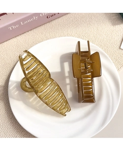 Two-piece minimalist amber hair claw clips set in oval and rectangular shapes on white tray