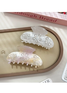 Macro view of crystal flower hair clips with marble texture on a leather tray