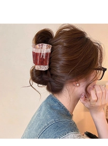 Pince à cheveux motif marbre marron avec détails en nacre dans une coiffure relevée
