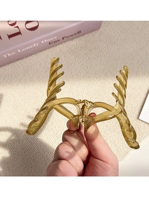 Close-up of a translucent amber hair claw clip with a strong golden metal spring