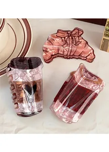 Détail des pinces à cheveux en acétate marbré en forme de tasse à café et croissant