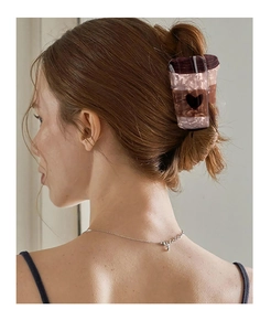 Détail d'une pince à cheveux tasse à café avec motif cœur sous une lumière douce