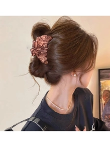 Détail macro d'une pince à cheveux nœud en écaille marron foncé sur un modèle