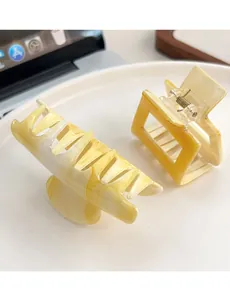 Détail de pinces à cheveux en acétate marbré jaune et blanc de styles variés