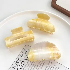 Lot de trois pinces à cheveux jaune crème motif marbre aux formes géométriques variées