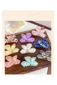 Detailed close-up of marble acetate butterfly hair claws with rhinestone centers