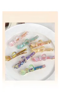 Dettaglio di fermagli per capelli in acetato a fiocco in vari colori pastello su vassoio