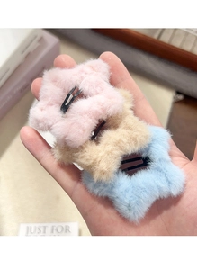Gedetailleerde close-up van zachte pluche sterrenhaarspelden in roze en blauw