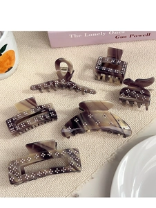 Detailed set of 6 tortoiseshell acetate hair clips with crystal flower accents on white fabric