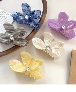 Detailed close-up of acetate butterfly hair claws with rhinestone centers in five colors
