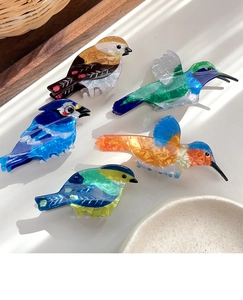 Set of five vibrant acetate bird-shaped hair claws with marble textures and silk finish