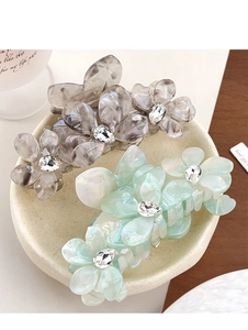 Détail de pinces à cheveux fleur en acétate avec texture marbrée et strass brillants