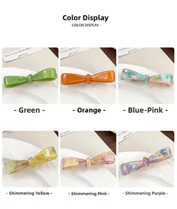 Vue détaillée de barrettes à nœud en acétate en six couleurs avec texte fait à la main