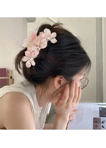 Détail d'une pince à cheveux en fleur d'acétate rose pâle ornée de strass brillants