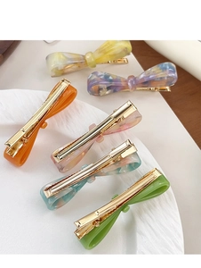Détail de six barrettes à cheveux nuds en acétate coloré avec texte France Handmade