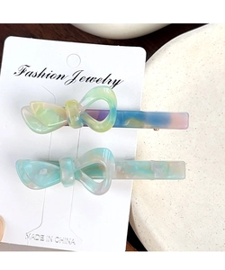 Dettaglio di fermagli per capelli in acetato a fiocco con trama marmorizzata