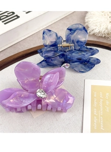Detail of acetate flower hair claws with marble texture and sparkling rhinestones
