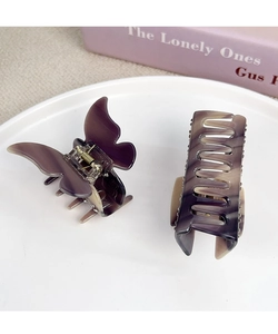 Detail of marble pattern acetate butterfly and rectangle hair claw clips in a minimalist dish