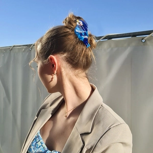 Cute blue bird hair claw clip in acetate material styled on a model's updo hairstyle