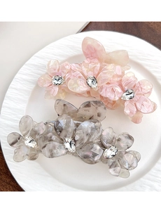 Détail de pinces à cheveux fleur en acétate avec texture marbrée et centre en cristal brillant