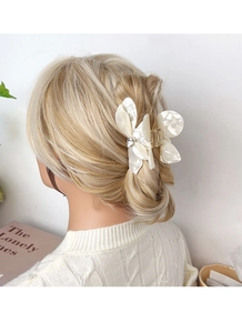 Detailed view of a white butterfly hair claw clip with crystal on blonde hair
