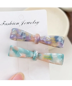 Détail de barrettes nœuds en acétate violet et bleu sur carte France Handmade