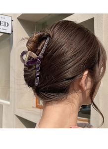 Detail of tortoiseshell acetate claw clip with crystals on a woman's half-up hairstyle