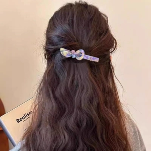 Elegante fermaglio per capelli a fiocco in acetato viola sfumato su capelli castani