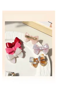 Détail de barrettes à nœud en acétate avec textures marbrées et couleurs unies