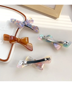 Macro detail of French style acetate bow hair clip with engraved Coucou France lettering