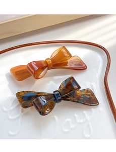 Detail of tortoiseshell acetate bow hair clips with Barrette La France gold lettering