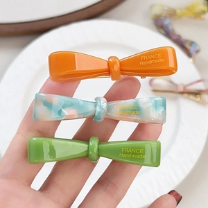 Trois barrettes nœud en acétate orange, bleu et vert avec finition marbrée