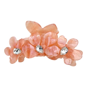 Pince à cheveux fleur en acétate rose avec texture marbrée et strass sur fond blanc
