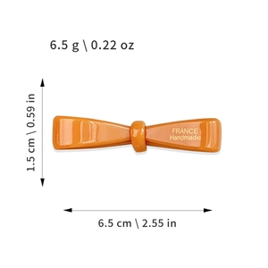 Barrette nœud en acétate orange avec logo doré et mesures de taille précises