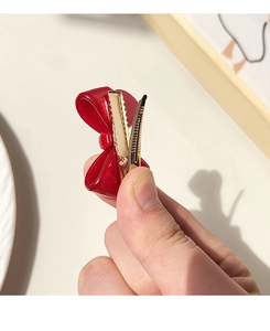 Macro shot of dark red bow hair clip showing the durable gold duckbill metal clasp detail