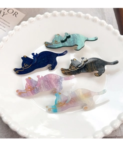 Détail de pinces à cheveux chat en acrylique coloré avec motifs marbrés dans un plat