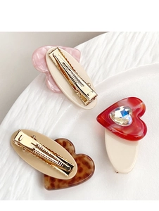 Detailed view of 3-piece heart hair clips with pink marble and leopard patterns