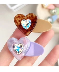 Detailed close-up of heart-shaped hair clips with leopard print and marble textures