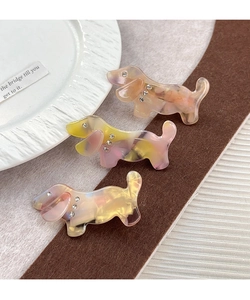 Gros plan de trois barrettes teckel en acétate avec motifs marbrés et strass brillants