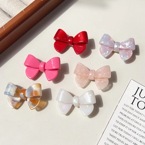 Barrettes à cheveux en acétate en forme de nœud en six couleurs et motifs marbrés sur table