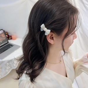 Élégante barrette à cheveux nœud en acétate blanc portée par un mannequin en scène
