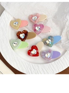 Detail of heart hair clips with acetate textures and sparkling crystal rhinestones