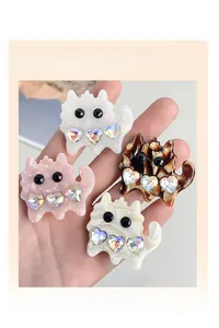 Close-up of four cute cartoon cat hair claw clips with colorful heart rhinestones