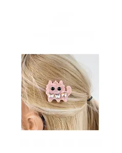 Close-up of pink cat-shaped hair clip with heart-shaped rhinestones on blonde hair